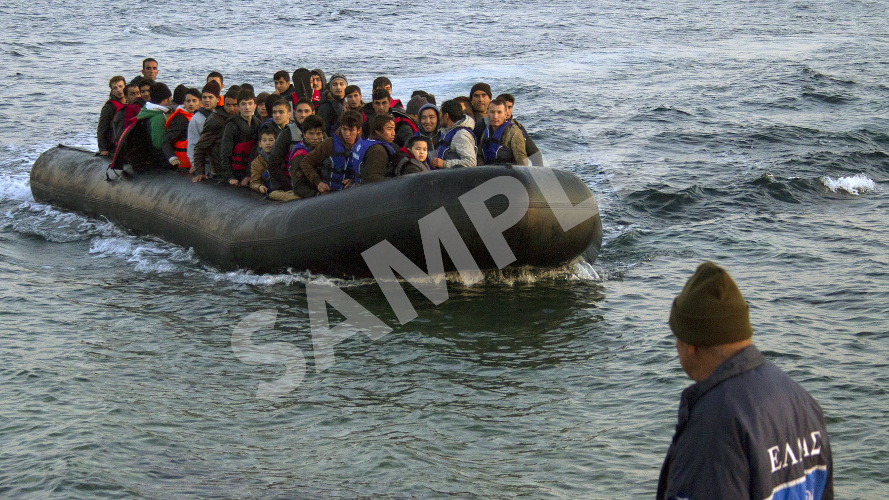 Refugees in a crowded raft arrive on the shores of Lesbos, Greece.